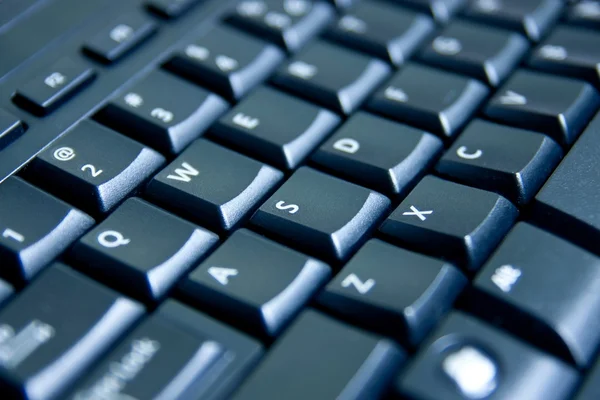 Nahaufnahme schwarze Computertastatur, blau getöntes Licht — Stockfoto
