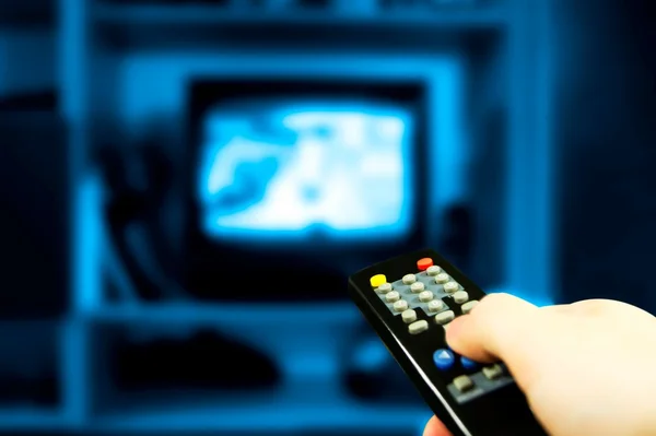 Hand som håller TV-fjärrkontrollen — Stockfoto