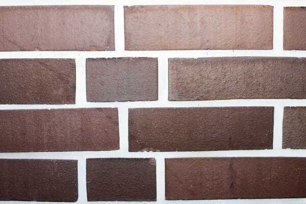 Wall with dark clinker bricks and white joints