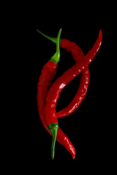 Red hot chili peppers over black — Stock Photo, Image