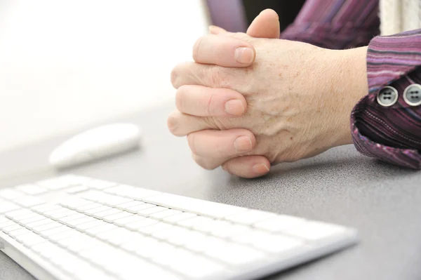 Handen van een oude vrouw te typen op het toetsenbord, geïsoleerde op wit, close-up. — Stockfoto