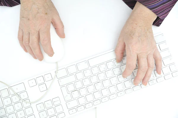 Τα χέρια του ένα παλιό θηλυκό δακτυλογράφηση στο πληκτρολόγιο, και χρησιμοποιώντας το ποντίκι, που απομονώνονται σε — Φωτογραφία Αρχείου