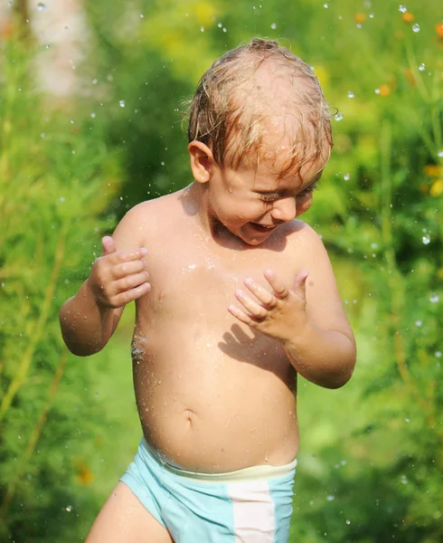 Kosten van een jongetje in de zomerregen — Stockfoto