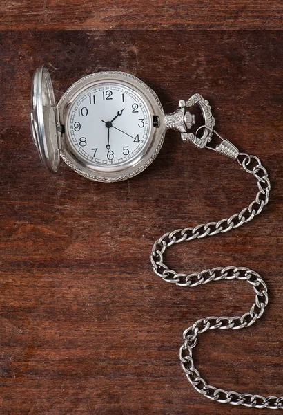 Die alte Uhr auf einer hölzernen Oberfläche — Stockfoto