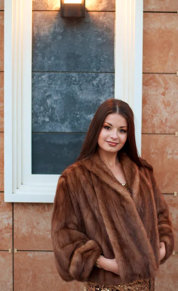 Portrait of luxurious young woman in a fur coat — Stock Photo, Image