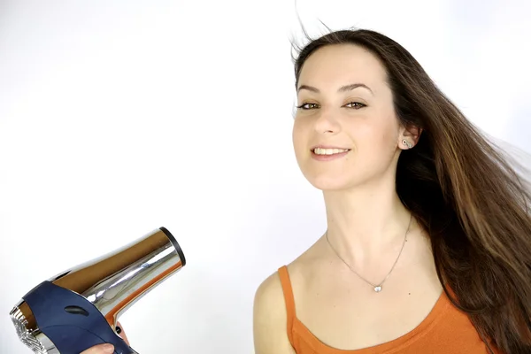 Weibliches Modell föhnen ihre langen brünetten Haare — Stockfoto