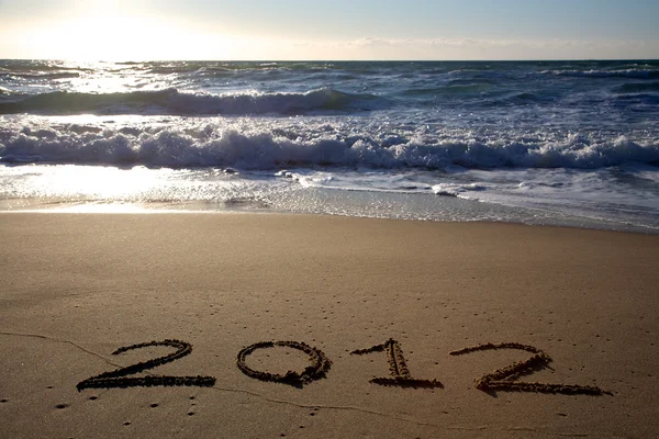 2012 escrito na praia horizontal com ondas — Fotografia de Stock