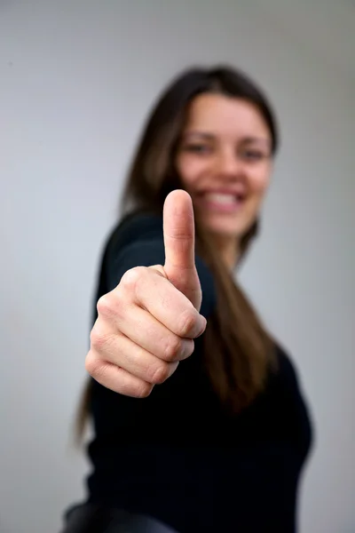 Крупный план молодой женщины с большим пальцем вверх улыбаясь — стоковое фото