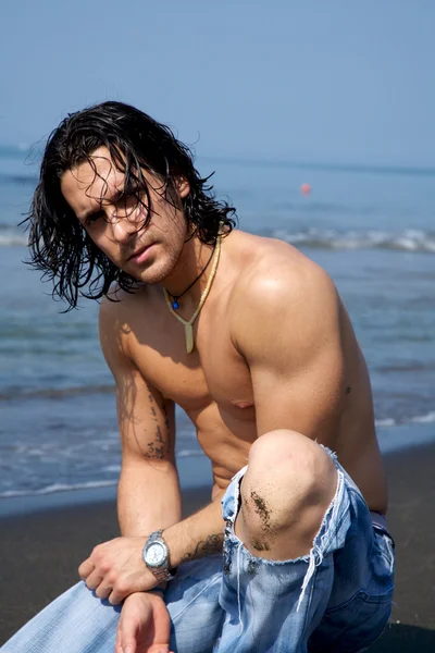 Gespierde mannelijk model op het strand — Stockfoto