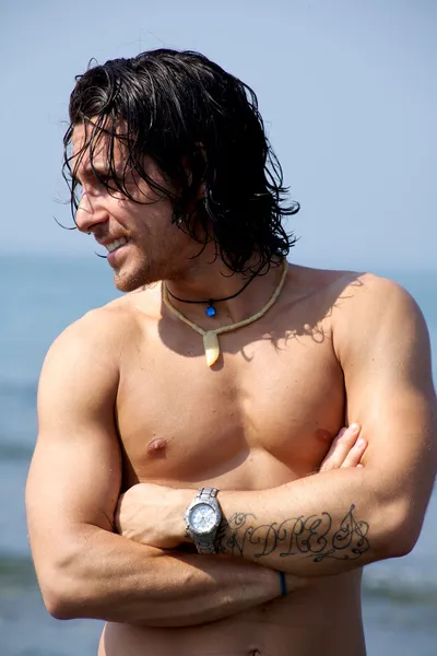 Gelukkig mannelijk model op het strand Stockfoto