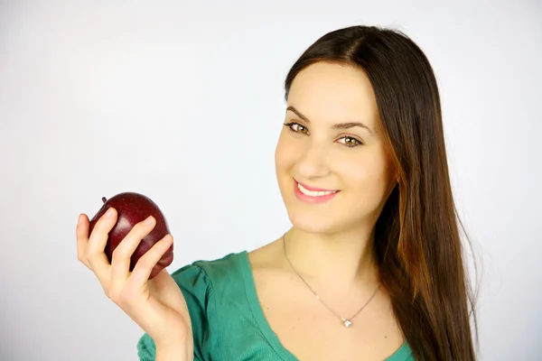 Молодая девушка улыбается с красным яблоком — стоковое фото