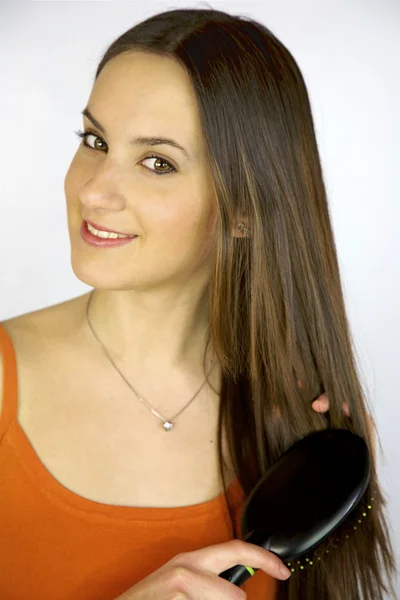 Ženský model kartáčování dlouho bruneta vlasy — Stock fotografie