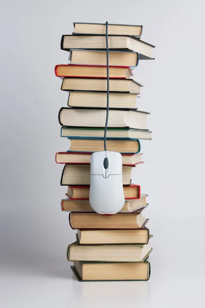 Белая компьютерная мышь с книгами — стоковое фото