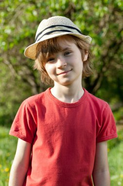 The fair-haired boy in red shirt and hat clipart