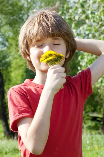 Tiener geniet geuren van paardebloemen — Stockfoto