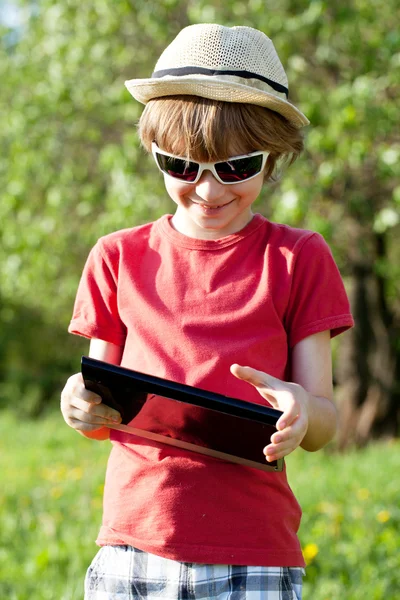 Vrolijke jongen speelt in de tablet pc — Stockfoto