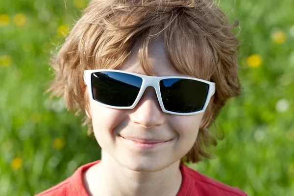 Rubia travieso niño usando gafas de sol —  Fotos de Stock