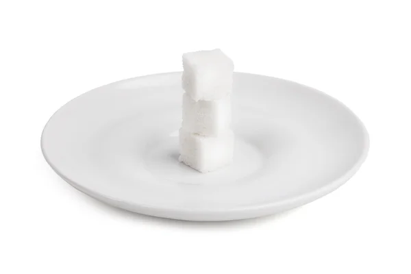 Drie brokken van suiker op een witte porseleinen schaal — Stockfoto