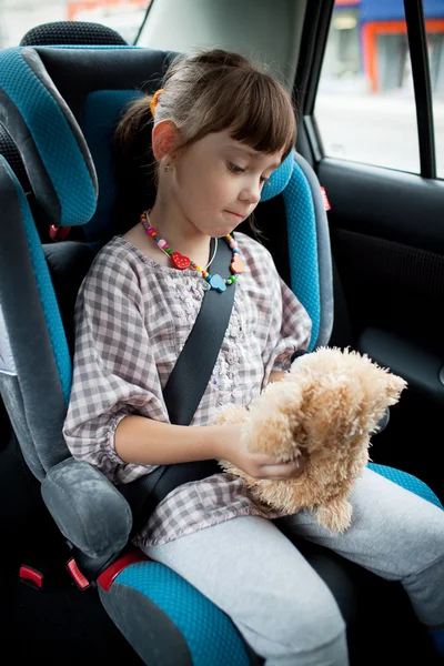 stock image The little girl sits in a car