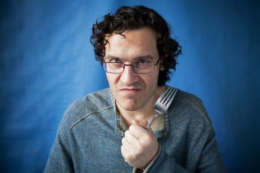 Man threatening species with fork in hand clipart