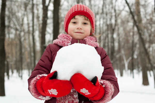 Niña con una bola de nieve en sus manos — Foto de Stock