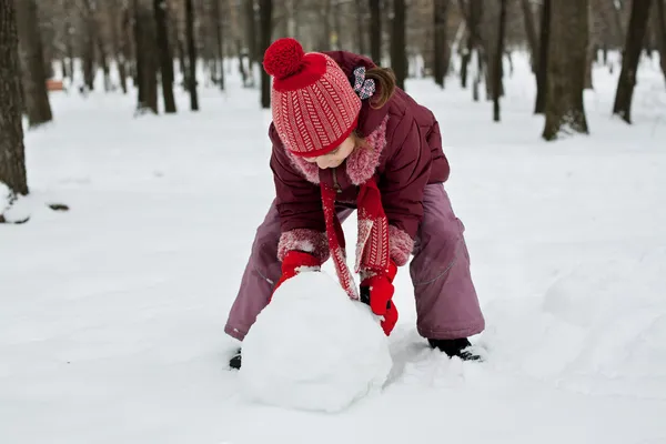 Het kleine meisje lag een sneeuwpop — Stockfoto