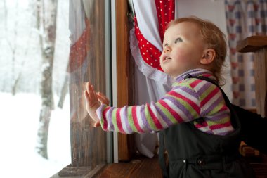 küçük kız pencereden dışarı bakarak
