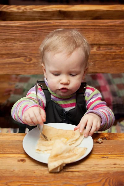 Blondes Mädchen isst leckere Pfannkuchen — Stockfoto