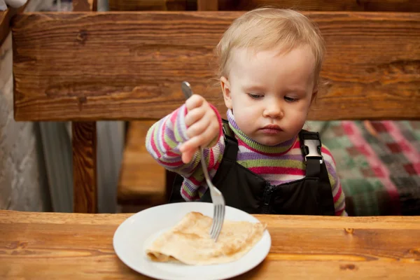 Blond little girl eats pancakes — Stock Photo, Image
