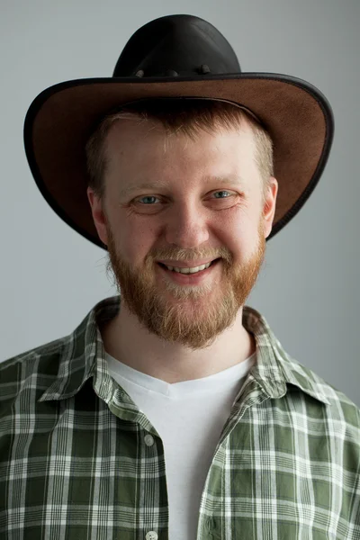 stock image The good-natured cowboy hat and a green plaid shirt