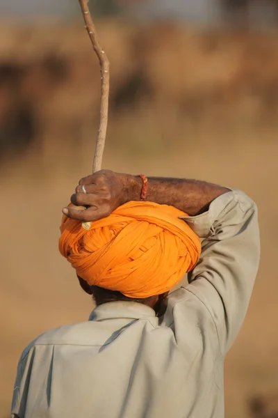 Orange turban och stick — Stockfoto