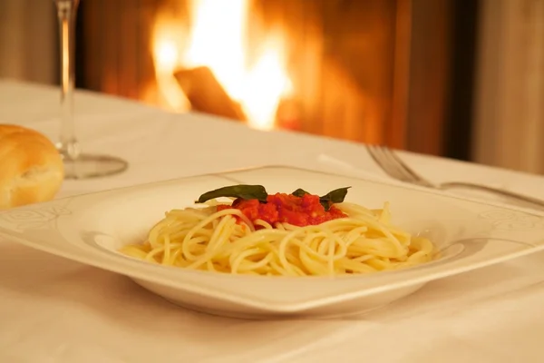 따뜻한 벽난로 앞에서 스파게티 접시 스톡 사진