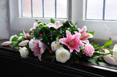 Pink and whiter flowers decorate church.