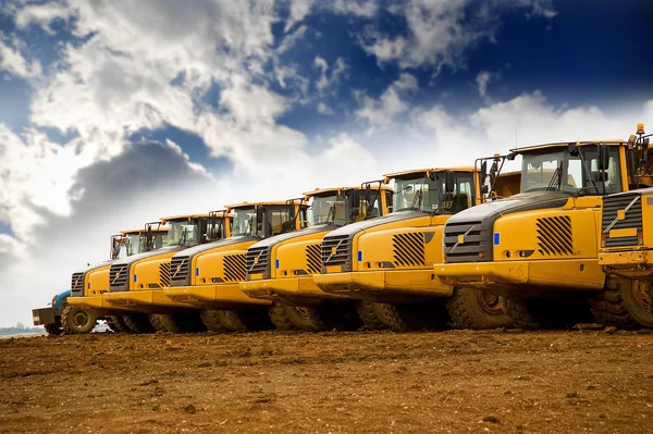 Sor sárga nehéz billenő teherautók — Stock Fotó