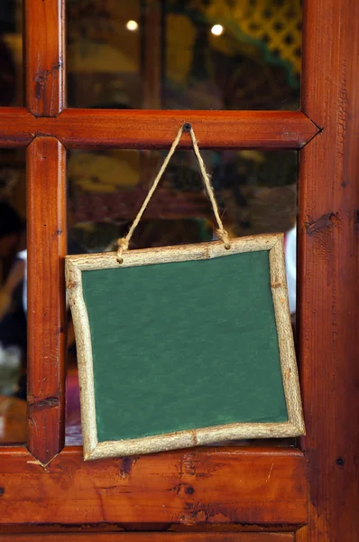Ahşap çerçeve ile boş yazı tahtası kapıya asıldı — Stok fotoğraf