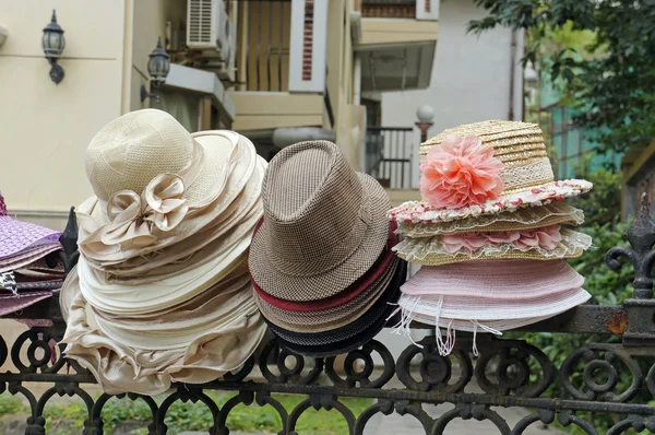 Assorted hats on fence — Stock Photo, Image