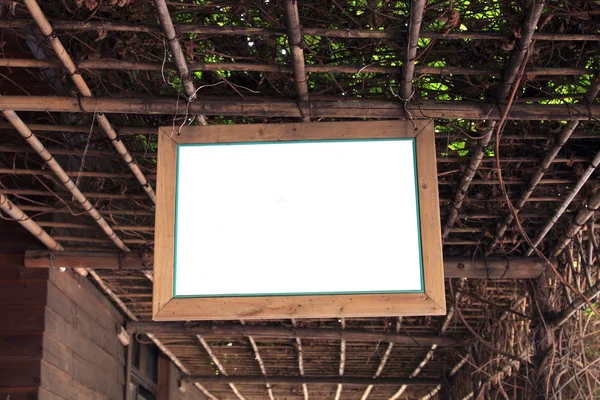 stock image Blank wooden board hanging on the bamboo fence