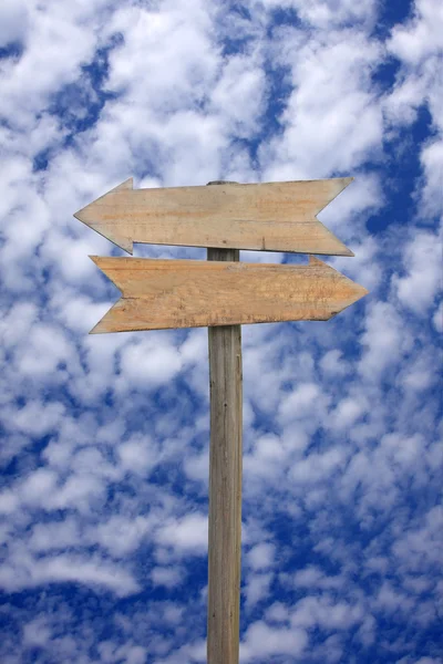 Blankes Holzpfeil-Schild gegen blauen Himmel — Stockfoto