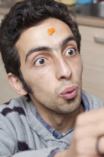 Junger Mann mit einem Stück Mandarine — Stockfoto