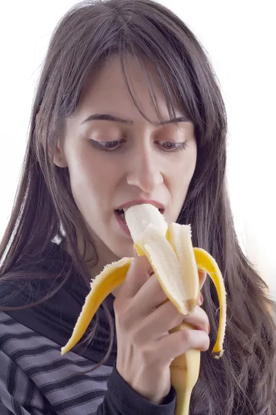 A rapariga está a comer uma banana. — Fotografia de Stock