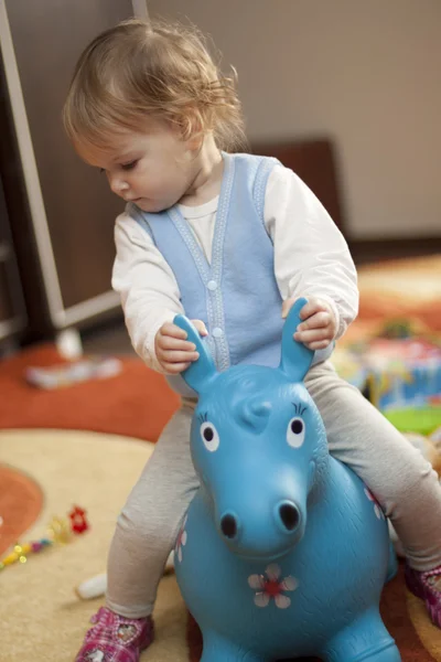 Bambino cavalcando un cavallo giocattolo — Foto Stock