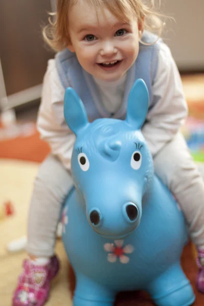 Baby riding a toy horse — Stock Photo, Image