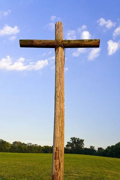 Uma cruz de madeira robusta e céu azul e nublado — Fotografia de Stock