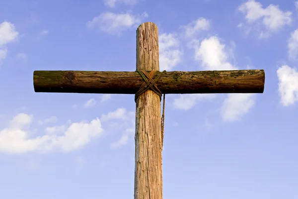 Een robuuste houten kruis en blauw, bewolkte hemel — Stockfoto