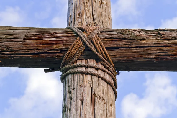 Close-up van een robuuste houten kruis en blauw, bewolkte hemel — Stockfoto