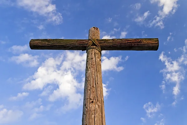 Ein schroffes Holzkreuz und blauer, bewölkter Himmel — Stockfoto