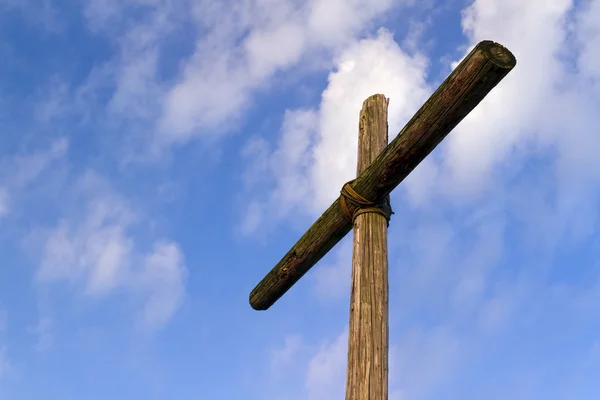 Robustní dřevěný kříž a obloha modrá, zataženo — Stock fotografie
