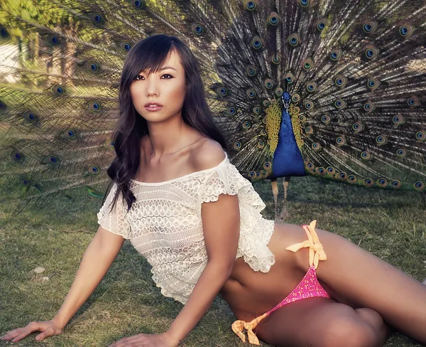 孔雀を持つ美しいエキゾチックな若い女性 — ストック写真