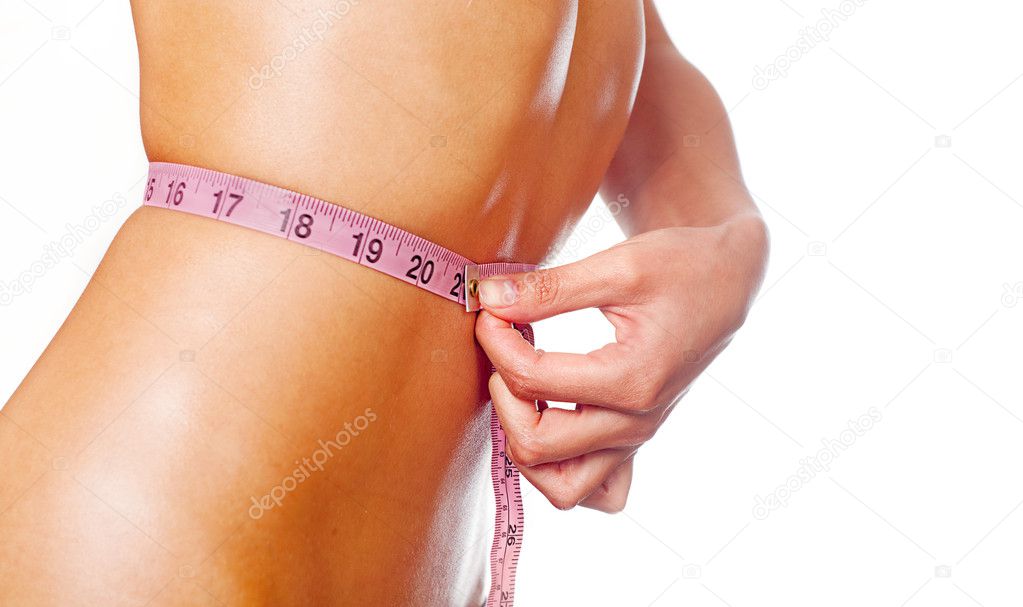 Fit slim young woman measuring her waist