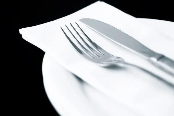 Knife and Fork with napkin on plate — Stock Photo, Image